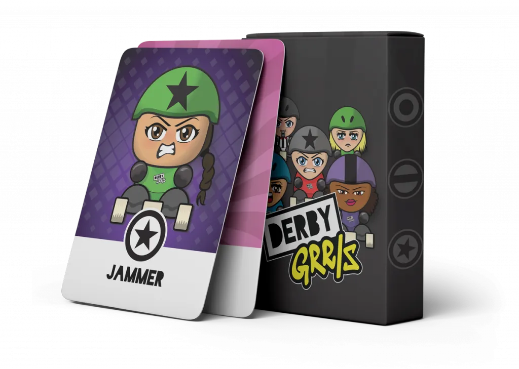 A deck of the DerbyGrrls game standing upright in an empty space. Two cards are leaned against the outside of the box. The visible card on top shows a vibrant illustration of a roller derby skater with a single brown braid. She wears a star on her helmet and has a star symbol and the word Jammer at the bottom of the card.